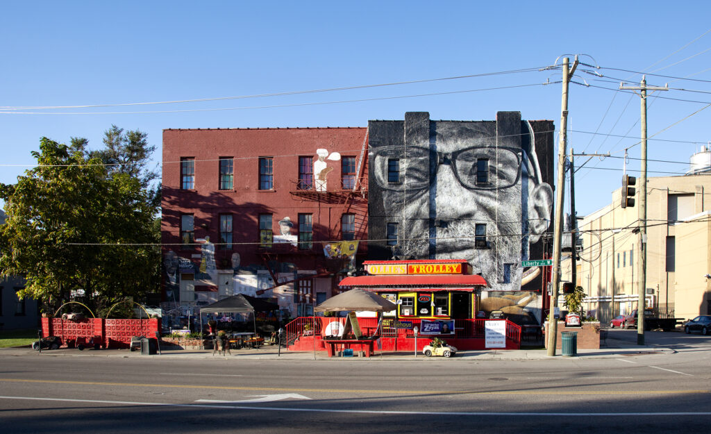 A mural depicting artist William Rankins Jr. on the side of Ollie's Trolley, seen from Liberty Street in Cincinnati, Ohio.